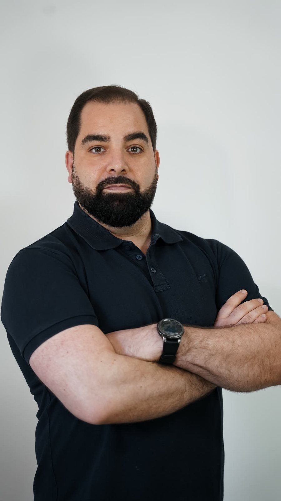Retrato de Mário Pereira, fisioterapeuta, de braços cruzados, a olhar de frente.